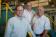 Researchers Greg Krumdick, Osman Levent Eryilmaz and Ali Erdemir stand in front of the large-scale ultra-fast boriding furnace, which rapidly converts the surface of metal or alloy mechanical parts into a hard, durable boride layer. At full capacity, the furnace can treat millions of industrial parts per year. Compared to conventional boriding, the new technique substantially cuts down on time, energy and money.