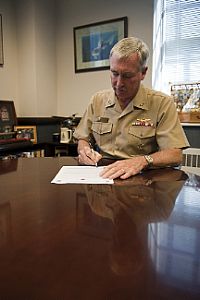 Rear Adm. Tim Alexander, commander of Navy Region Mid-Atlantic, signs a proclamation declaring October as Domestic Violence Awareness Month.