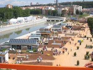 Photo of the Villa Solar, which stretches along a river. People walk along pathways on both sides.