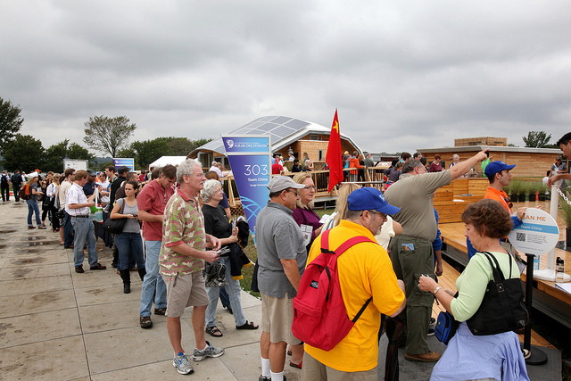 Photo of a line of people waiting to tour a Solar Decathlon house. 