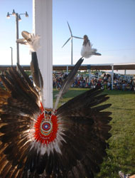 Photo of a teepee and a wind turbine.