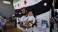 A Syrian man, who fled his home due to government shelling, holds his son as they take refuge at Bab Al-Salameh crossing border, hoping to cross to one of the refugee camps in Turkey, near the Syrian town of Azaz, Sept. 12, 2012.  