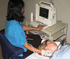Photo of technician using ultrasound to test the carotid artery of a patient