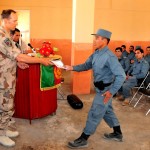 Swedish Army Capt. Johannes Kirchheim, the Training Sustainment Site Shaheen lead police mentor, presents a graduation certificate to a basic patrolman course graduate. There were 114 graduates in the ceremony June 2. The site fields between 600 and 700 new patrolmen annually for the northern region of Afghanistan. (Air Force photo by Tech. Sgt. Mike Andriacco)