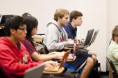 Row of students in class with laptops