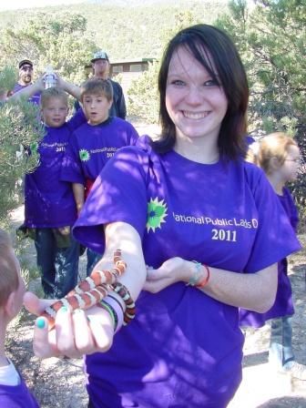 Stephanie Hansen of Ely, NV learning the lesson on snake handling, A small mountain king snake wrapping itself around her arm.