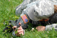 Spc. Christy Anthony, Headquarters and Headquarters Company, Combined Arms Center, Special Troops Battalion, demonstrates how to hold a weapon while low-crawling at a warrior task station testing her technical and tactical skills during the CAC