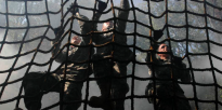Soldiers climbing cargo net obstacle