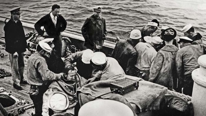 Crewmen suit-up two Deep Sea Divers during the rescue/salvage operation