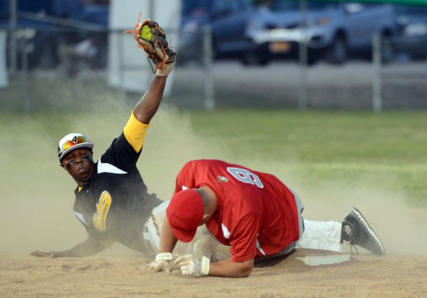 All-Army infielder Staff Sgt. Maikeld Quarles of Yuma Proving Ground, Ariz., displays softball in glove after applying a tag to All-Marine Corps Sgt. Christopher Aldape of Marine Corps Base Quantico, Va., during the 2012 Armed Forces Softball Championships at the Cannoneer Complex on Fort Sill, Okla.