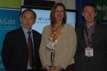 Secretary Steven Chu with Kellie Walsh and Cris Dorman of Greater Indiana Clean Cities at the Green Truck Summit in Indianapolis, IN, in front of a display describing the coalition's Recovery Act-supported project. | Photo by Trish Cozart, NREL.