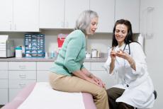 Fotografía de una doctora explicando el uso de medicamentos a una paciente