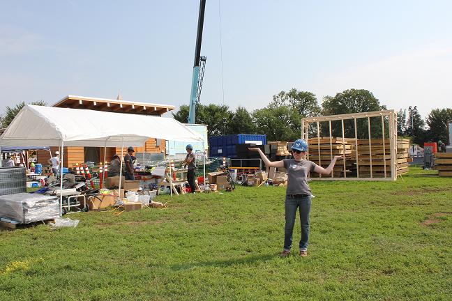 Photo of woman wearing a hard hat and holding her arms wide.