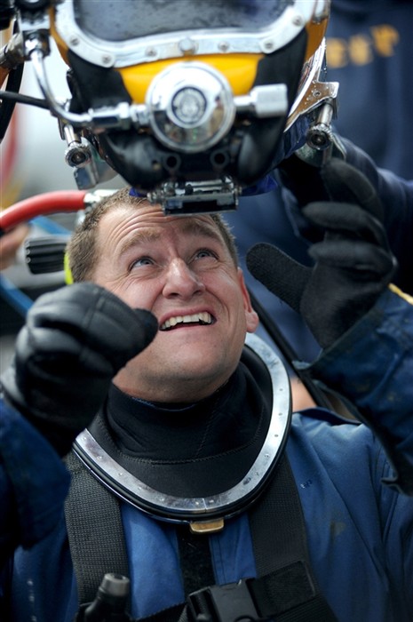NORTH SEA (July 21, 2011) Chief Navy Diver Geoff Smitman of Mobile Diving and Salvage Unit (MDSU) 2, dons his KM 37 surface supply diving helmet aboard the Military Sealift Command rescue and salvage ship, USNS Grasp (T-ARS 51).  Grasp, MDSU-2 and Navy archeologist, scientist, and historians are currently deployed to the North Sea to conduct diving expeditions. (U.S. Navy Photo by Mass Communication Specialist 1st Class Ja&#39;lon A. Rhinehart/RELEASED)