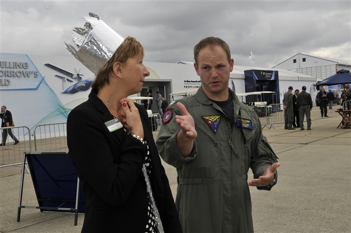 U.S. Navy Lt. Adam Farber, Strike Fighter Weapons School Pacific weapons system officer, explains the vast capabilities of the F/A-18E Super Hornet to Benedicte Bastid ATR Aircraft hospitality representative, July 10, 2012, during the Farnborough International Air Show in Farnborough, England. Approximately 90 aircrew and support personnel from bases in Europe and the United States are participating in the air show. Participation in this premier event demonstrates that U.S. defense industry offers state-of-the-art capabilities vital for the support and protection of our allies’ and partners’ national-security interests.
