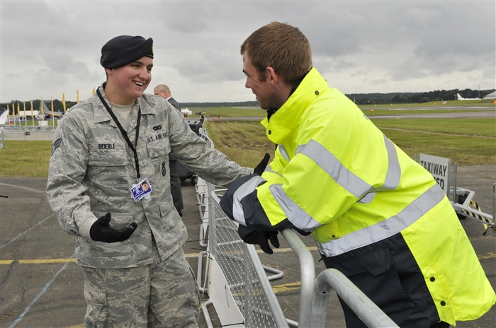 U.S. Air Force Senior Airman Kevin Beierle, 48th Security Forces Squadron patrolman, talks with Darrel Carter RJA Security officer, July 10, 2012, during the Farnborough International Air Show in Farnborough, England. Approximately 90 aircrew and support personnel from bases in Europe and the United States are participating in the air show. Participation in this premier event demonstrates that U.S. defense industry offers state-of-the-art capabilities vital for the support and protection of our allies’ and partners’ national-security interests.