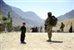 A local Afghan boy looks on as U.S. Navy Petty Officer 2nd Class Kenneth Jones pulls security during a mission to Pur Chaman district, Farah province, Afghanistan, Sept. 26, 2012.  U.S. Air Force photo by Staff Sgt. Jonathan Lovelady