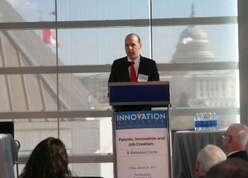 Kappos on podium at the Newseum in Washington with U.S. Capitol in background