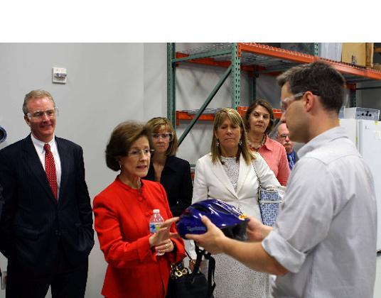 Dignitaries look at a Helmet