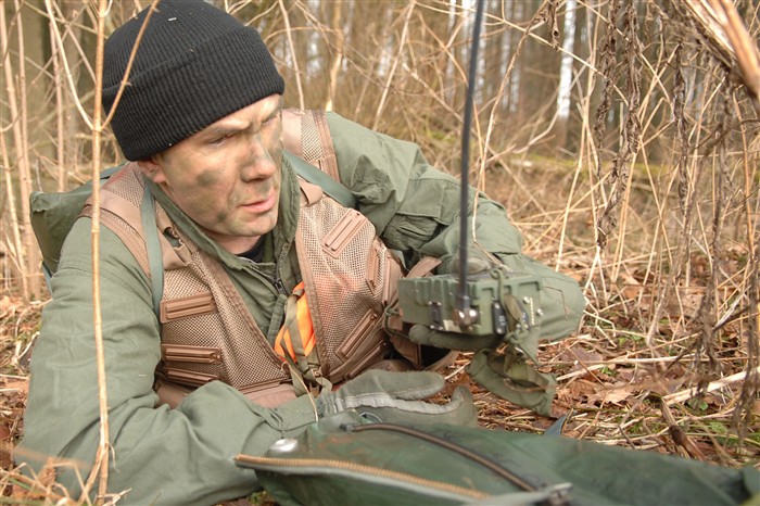 SPANGDAHLEM AIR BASE, Germany &mdash; Air Force Staff Sgt. Robert A. Martin, 52nd Operations Support Squadron, uses a survival radio while trying to conceal himself from opposing forces during a Survival Evasion Resistance and Escape training exercise here, Jan 27. The purpose of the course was to offer training to evade and escape enemy forces. (Department of Defense photo by Air Force Airman 1st Class Nicholas Wilson) 