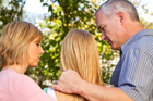 Two parents comfort their daugher