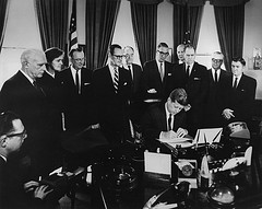 image of President Kennedy signing a bill in his office