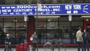 Pasengers wait for a bus outside one of the discount bus companies in the Chinatown neighborhood of New York, March 14, 2012.