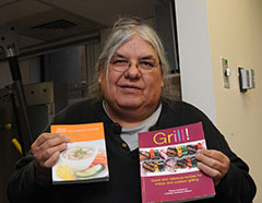 DIHFS client holding up two books, 200 low calorie recipes and Grill! Quick and delicious recipes for indoor and outdoor grilling.