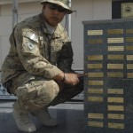 Petty Officer 2nd Class Joseph Nededog, Joint Medical Operations Center Bio Medical Equipment Technician Mentor working in Regional Support Command-West, points out his cousin’s name on Camp Stone’s memorial July 18, 2012 in Herat, Afghanistan.