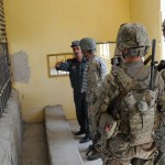 Lt. Col. Abdul Qayoum Azami, Farah City prison warden (left), leads a tour of the prison  in Farah City, in Farah City, Farah Province, Afghanistan, April 24. Coalition members are visiting the prison to observe and provide recommendations to improve conditions.