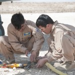 Afghan Air Force crew chiefs assigned to the Kandahar Air Wing, Kandahar Airfield, Afghanistan, rig and secure cables used for a sling load operation, at Forward Operating Base Eagle, Zabul province, Afghanistan. (Photo by Senior Airman Jessica Lockoski)