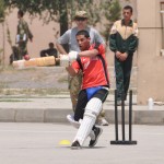 British Cmdr. Paul Snelling observes the batting style of a Kabul Military High School cadet during a cricket skills clinic held at the school.