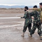 Italian air force 1st Marshall Ciro Tenace advises as Afghan airmen Abdull Fatho and Asis Ahmed extinguish a simulated helicopter crash March 6, 2011, at Shindand Air Base, Afghanistan. The airmen recently completed a four-month basic fire academy in Kabul. Marshall Tenace is an ITAF provider team adviser.