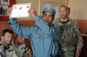 A graduation of the Afghan National Police training center at Training Support Center Shaheen, Balkh Province, shows off his certificate of completion July 12 during a ceremony. 