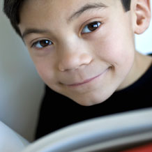 Boy smiling over book