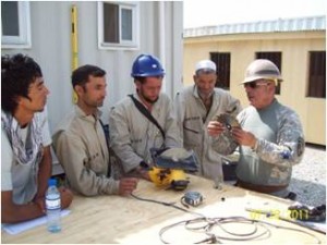 Staff Sgt. Joe Campos (right), with Infrastructure Training Advisory Group, gives on the job training to Afghans on the proper use of power tools. (Photo by Cpt. Jose Rocha)