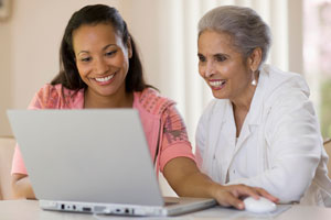 two women looking at a laptop