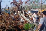 AmeriCorps members remove downed trees and other burnable debris from the roadside in Pass Christian, Miss.