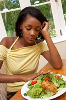 girl pushing plate of food away