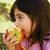 photo of a young girl eating an apple.