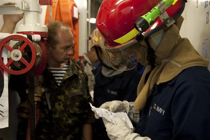 BOSPHORUS - Hull Maintenance Technician Fireman Justin Turner, right, reviews a damage report as Ukrainian navy Capt. Maxim Popov, left, observes during a damage control drill aboard the guided-missile destroyer USS Jason Dunham (DDG 109). Jason Dunham is on a scheduled deployment in support of maritime security operations and theater security cooperation efforts in the U.S. 6th Fleet area of responsibility.