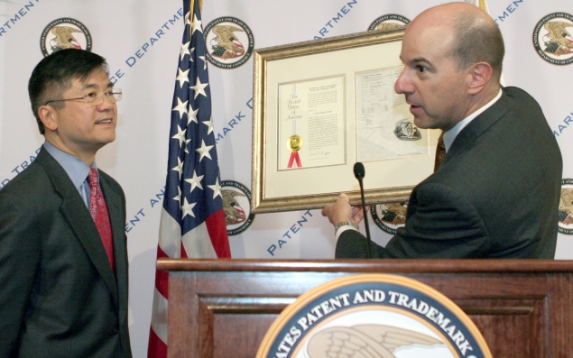 Under Secretary of Commerce for Intellectual Property and Director of the United States Patent Office (USPTO) David Kappos presents Commerce Secretary Gary Locke with a faux patent certificate during Locke's visit to the USPTO 