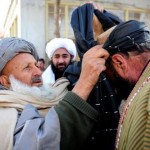 A respected tribal leader, Haji Aziz Argha wraps a Lungei headdress around a former insurgents head as a sign of his acceptance back in to society.  Twelve former insurgents chose to walk the path of peace this week as they were officially inducted into the Afghan Peace and Reintegration Program (APRP) at the provincial Governors compound in Tarin Kot, Uruzgan Province. The men were welcomed by an official party led by Uruzgan Governor Muhammad Omar Shirzad.  The APRP is an Afghan Government peace initiative designed and implemented by Afghans for Afghans. The program offers the opportunity for insurgents to voluntarily leave the fight so they can return to their communities with honor and dignity.  (Image by Corporal Raymond Vance)