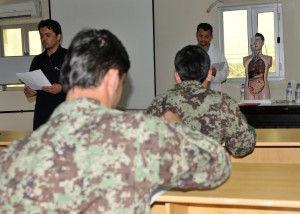 Dr. Navid Rahmani, left, a combat physician assistant course faculty training assistant, gives instructions to 53 Afghan National Security Force students of the course before they take a knowledge test at a Kandahar Regional Military Hospital classroom in southern Afghanistan, Apr. 23, 2012.