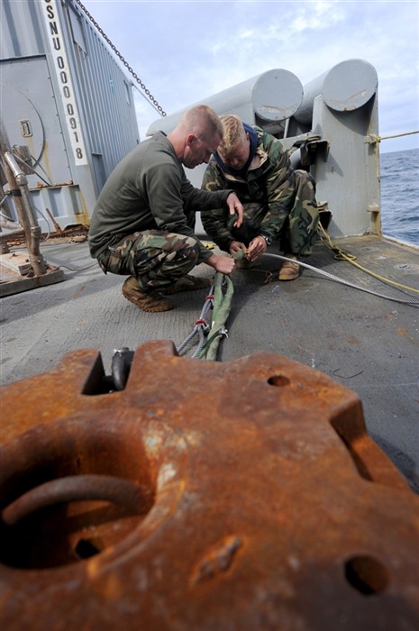 NORTH SEA (July 17, 2011) Navy Divers 1st Class, Will Queen (left) and Shawn Cooley, both stationed with Mobile Diving and Salvage Unit (MDSU) 2, attach a sling to the wire rope holding a clump on the aft deck of the Military Sealift Command rescue and salvage ship, USNS Grasp (T-ARS 51). Grasp, MDSU-2 and Navy archeologist, scientist, and historians are currently deployed to the North Sea to conduct diving expeditions. While verifying the sites of suspected shipwrecks, they hope to ultimately find the historic flagship of John Paul Jones, USS Bohnomme Richard. (U.S. Navy Photo by Mass Communication Specialist 1st Class Ja&#39;lon A. Rhinehart/UNRELEASED)