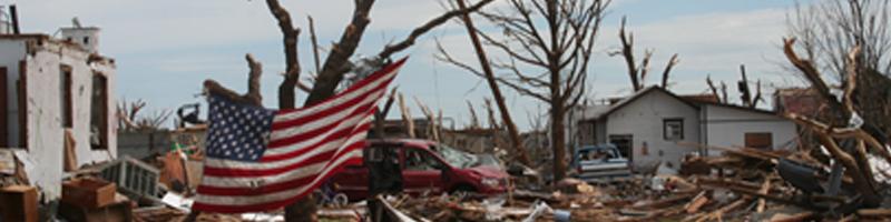May 4th, 2007. A neighborhood of homes demolished by the tornadoes. An American flag hangs on a tree.