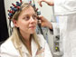 Image of a young woman being prepared by a researcher for a brain imaging system.