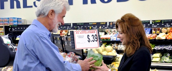 Quinon and Gretchen Ford, the owner's of Ford's Fine Food, admiring the affordable cabbage for sale at 39 cents each that was grown and purchased from a local producer.