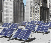 Photo of multiple photovoltaic arrays stand tilted on a rooftop with the Boston skyline as a backdrop.