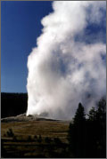 Photo of steam rising high in the air from a geyser.